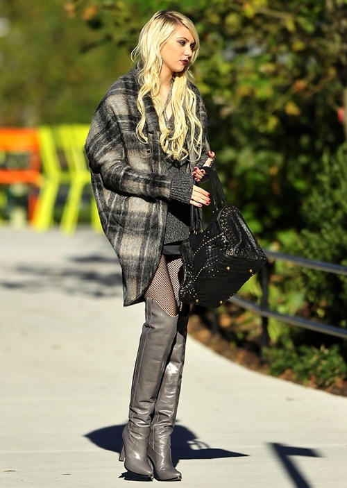 Chân dài 1m73 Taylor Momsen cá tính, mạnh mẽ khi kết hợp áo len tối màu, áo khoác dạ dáng rộng, váy ngắn, bốt da tông xám và tất lưới khêu gợi.
